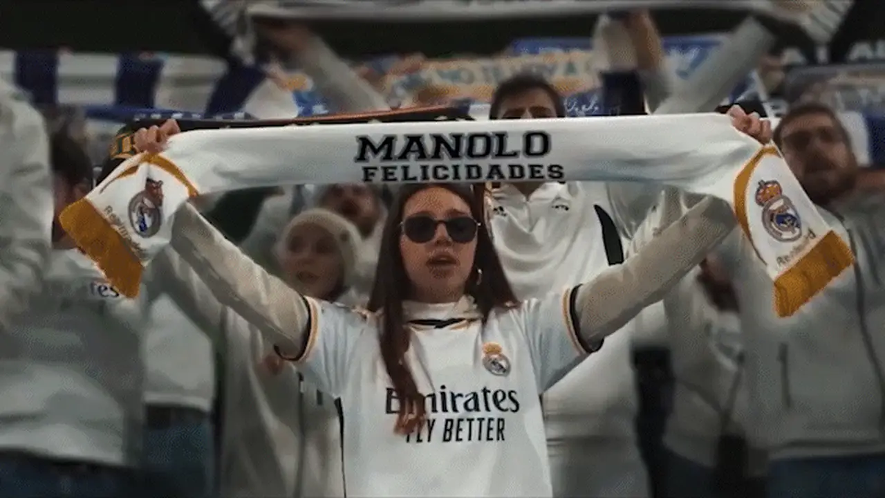 Una aficionada del Real Madrid levanta una bufanda con el nombre Manolo