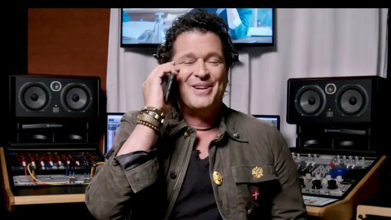 Carlos Vives al teléfono en un estudio de grabación